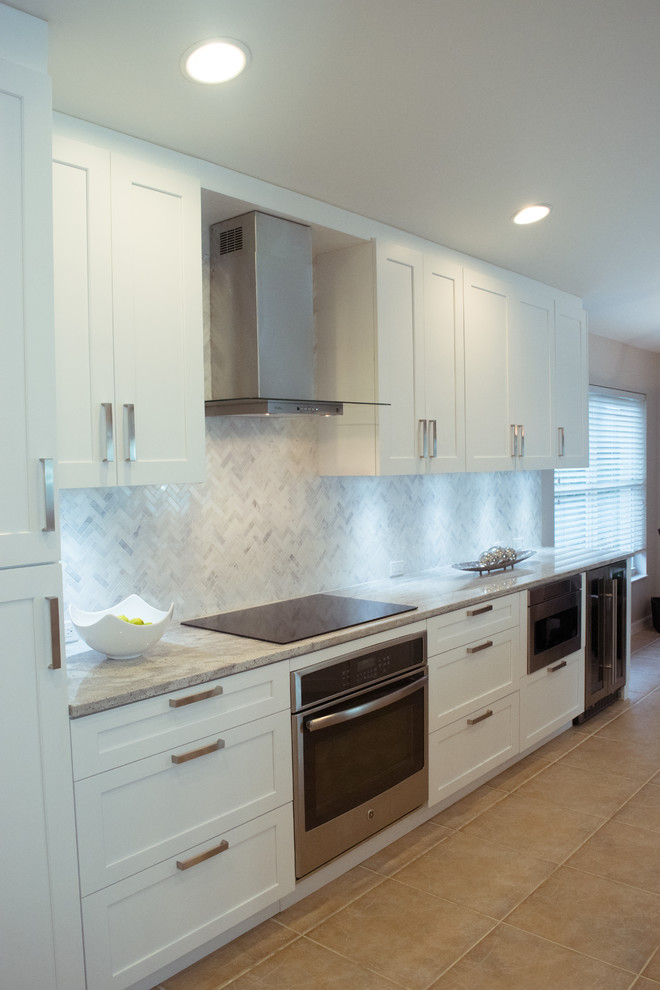 Example of a mid-sized transitional galley ceramic tile and beige floor eat-in kitchen design in Miami with an undermount sink, shaker cabinets, white cabinets, granite countertops, gray backsplash, stone tile backsplash, stainless steel appliances and a peninsula