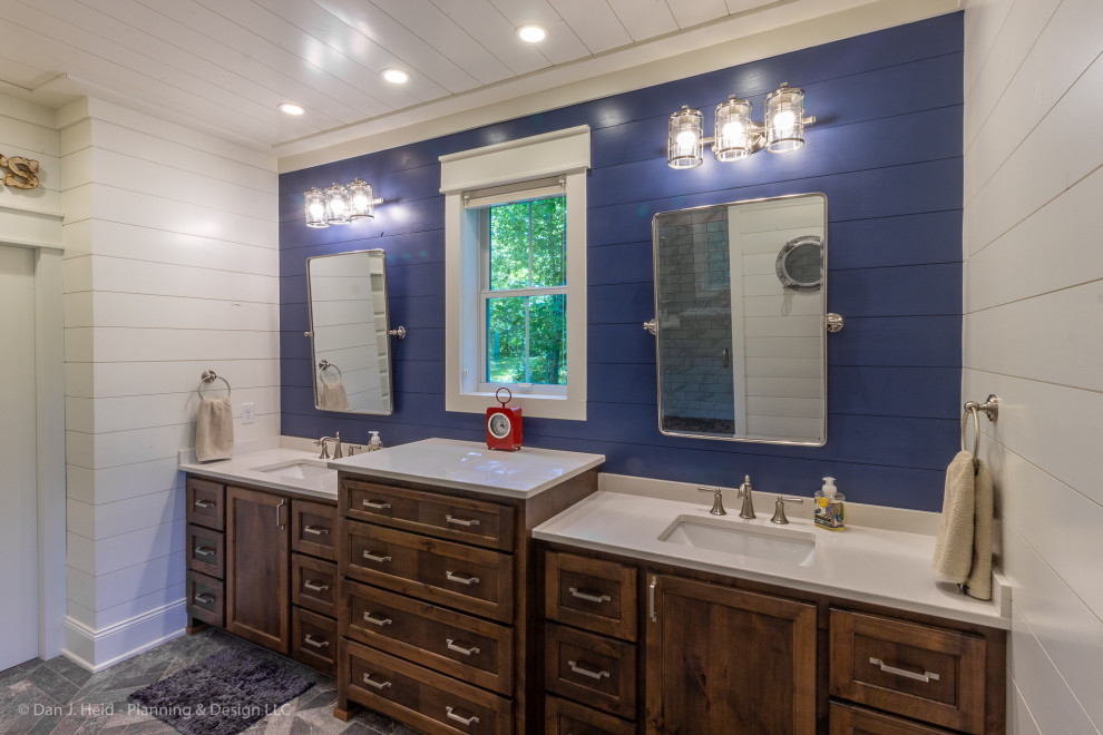 Design ideas for a mid-sized country master wet room bathroom in Minneapolis with flat-panel cabinets, brown cabinets, a two-piece toilet, blue walls, ceramic floors, an undermount sink, solid surface benchtops, grey floor, a hinged shower door and white benchtops.