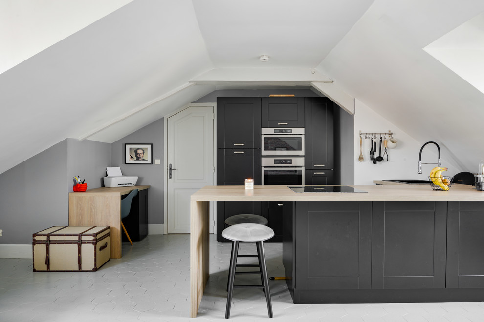 This is an example of a mid-sized scandinavian u-shaped open plan kitchen in Paris with a double-bowl sink, beaded inset cabinets, grey cabinets, wood benchtops, stainless steel appliances, terra-cotta floors, with island, grey floor and beige benchtop.