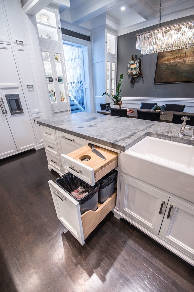 Example of a mid-sized transitional u-shaped dark wood floor eat-in kitchen design in Chicago with a farmhouse sink, recessed-panel cabinets, white cabinets, quartzite countertops, stone slab backsplash, stainless steel appliances, a peninsula and gray backsplash