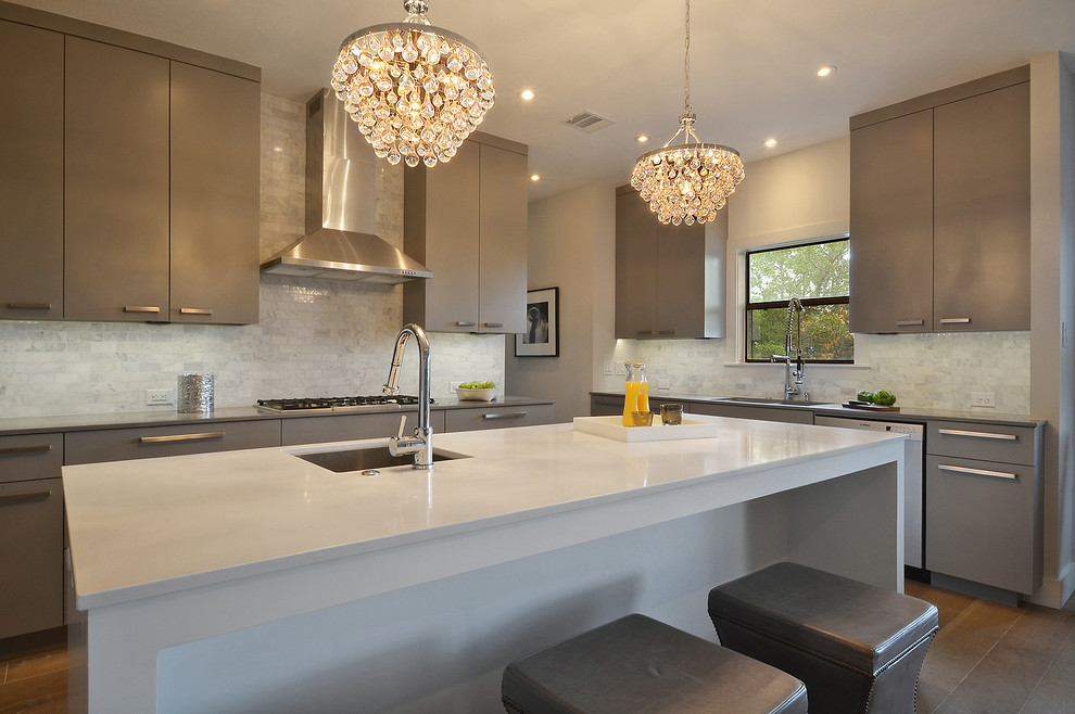 Photo of a transitional kitchen in Austin with a single-bowl sink, flat-panel cabinets, grey cabinets, white splashback, stone tile splashback and stainless steel appliances.