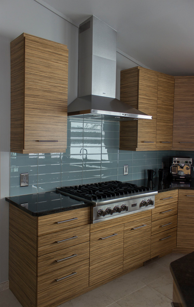 Photo of a large contemporary kitchen in Other with an undermount sink, flat-panel cabinets, granite benchtops, blue splashback, glass tile splashback, stainless steel appliances, ceramic floors and with island.