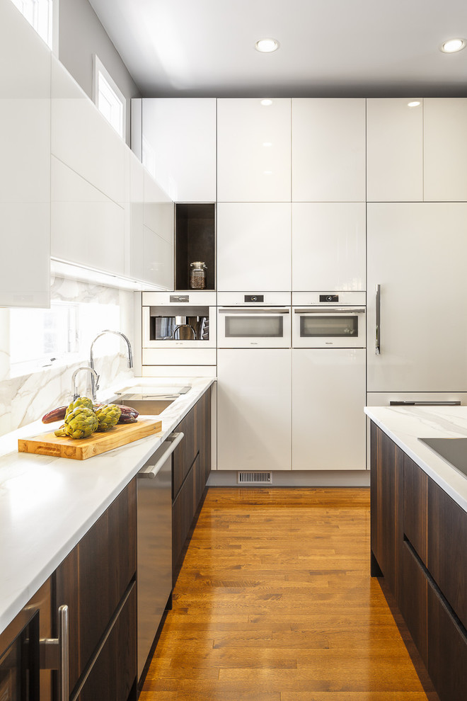 Photo of a mid-sized contemporary l-shaped eat-in kitchen in Ottawa with glass-front cabinets, white cabinets, marble benchtops, white splashback, white appliances, medium hardwood floors and with island.