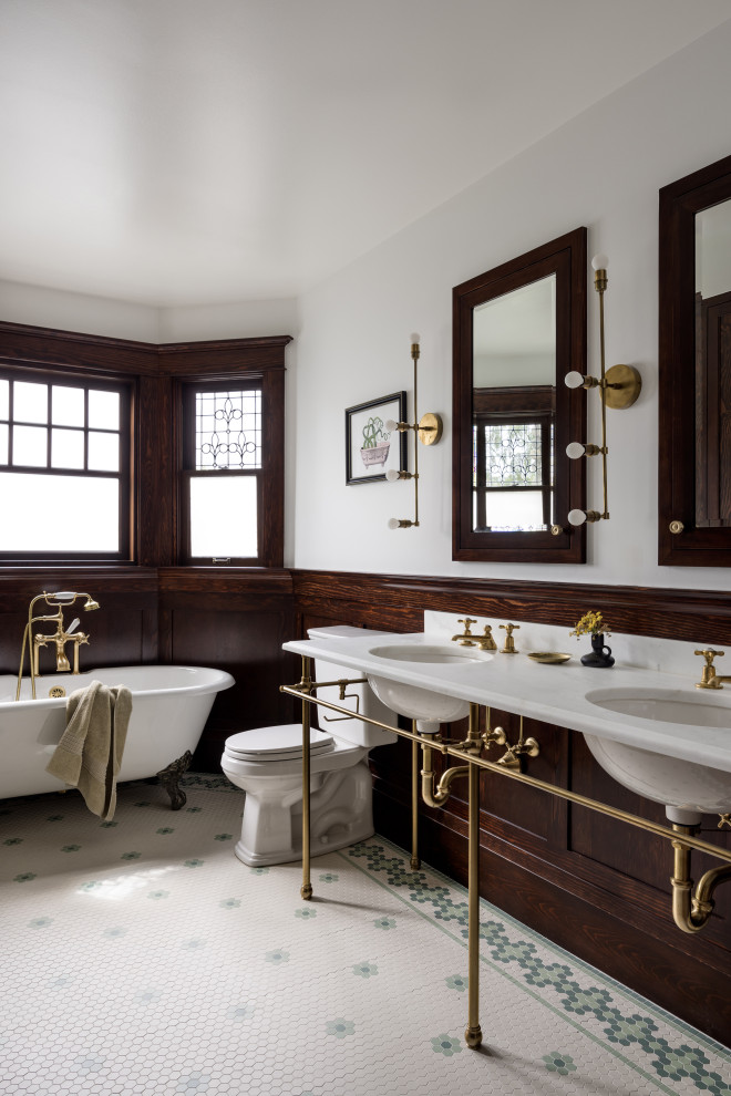 Inredning av ett amerikanskt stort vit vitt en-suite badrum, med ett badkar med tassar, en toalettstol med separat cisternkåpa, vita väggar, ett undermonterad handfat, marmorbänkskiva, flerfärgat golv och mosaikgolv