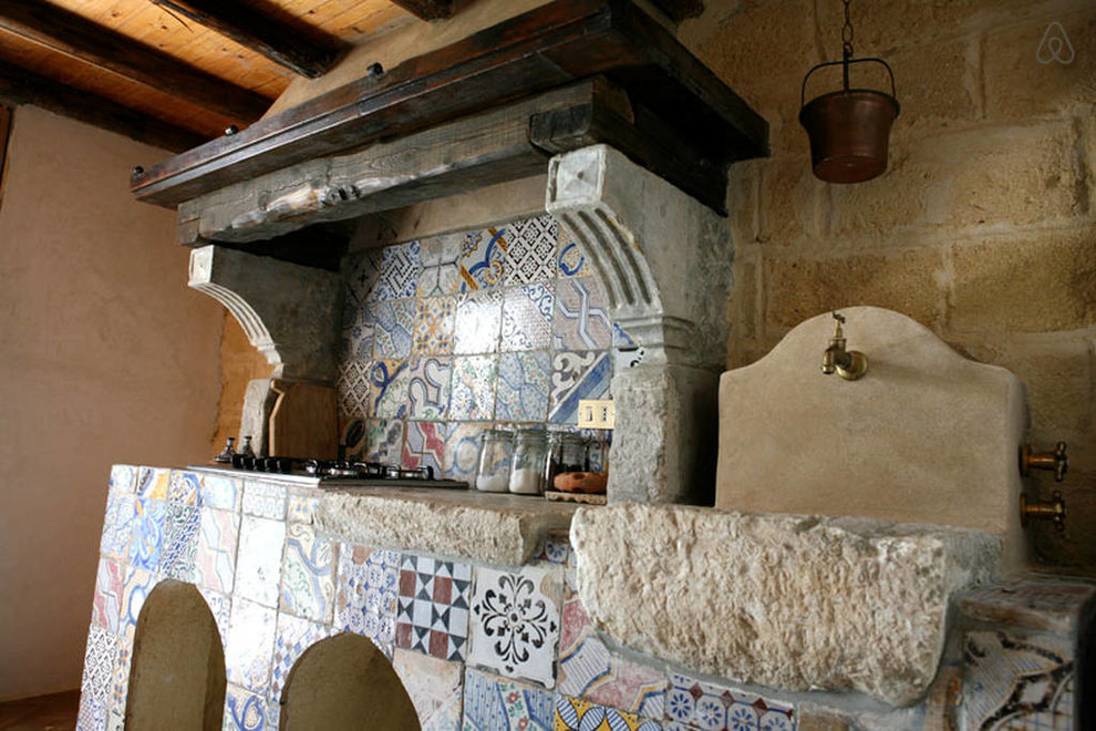 Inspiration for a large mediterranean u-shaped eat-in kitchen in New York with a farmhouse sink, open cabinets, beige cabinets, limestone benchtops, beige splashback, stone tile splashback, white appliances, limestone floors and with island.