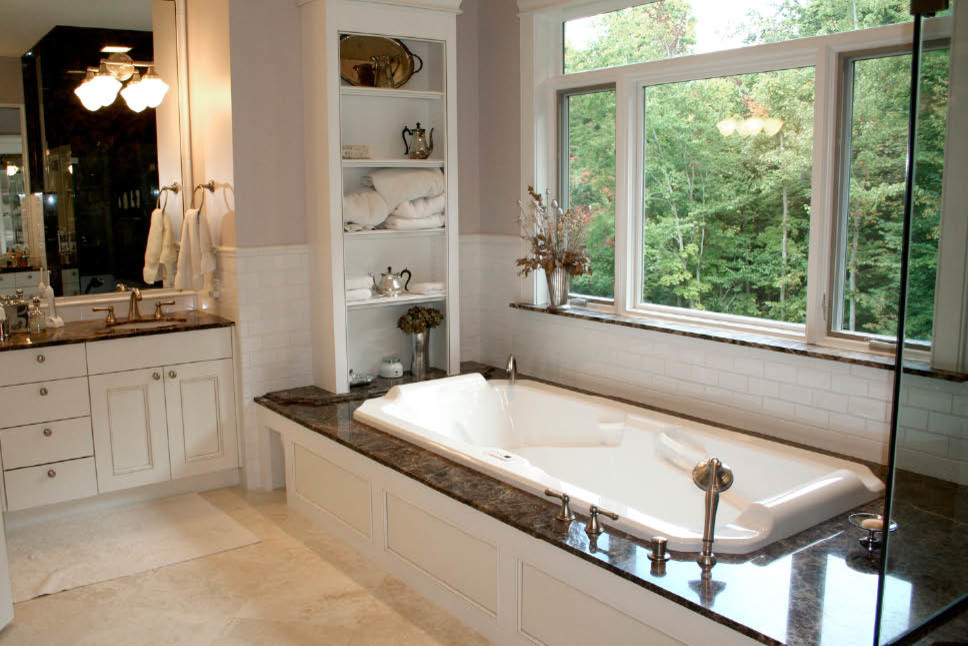 Photo of a large traditional master bathroom in Cleveland with an undermount sink, recessed-panel cabinets, white cabinets, granite benchtops, a hot tub, a corner shower, a one-piece toilet, beige tile, cement tile, beige walls and ceramic floors.