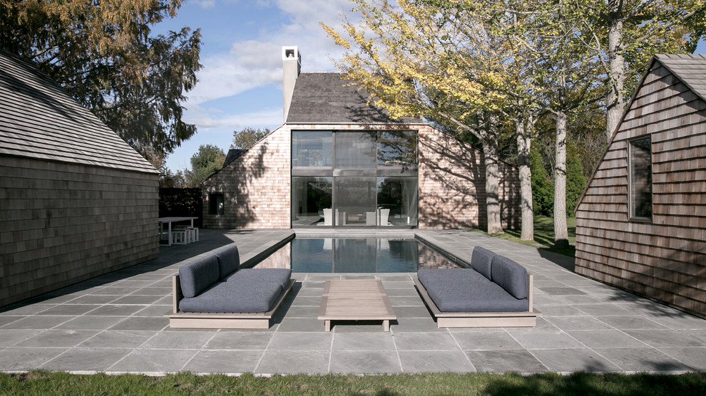 Transitional rectangular pool in New York with a pool house.