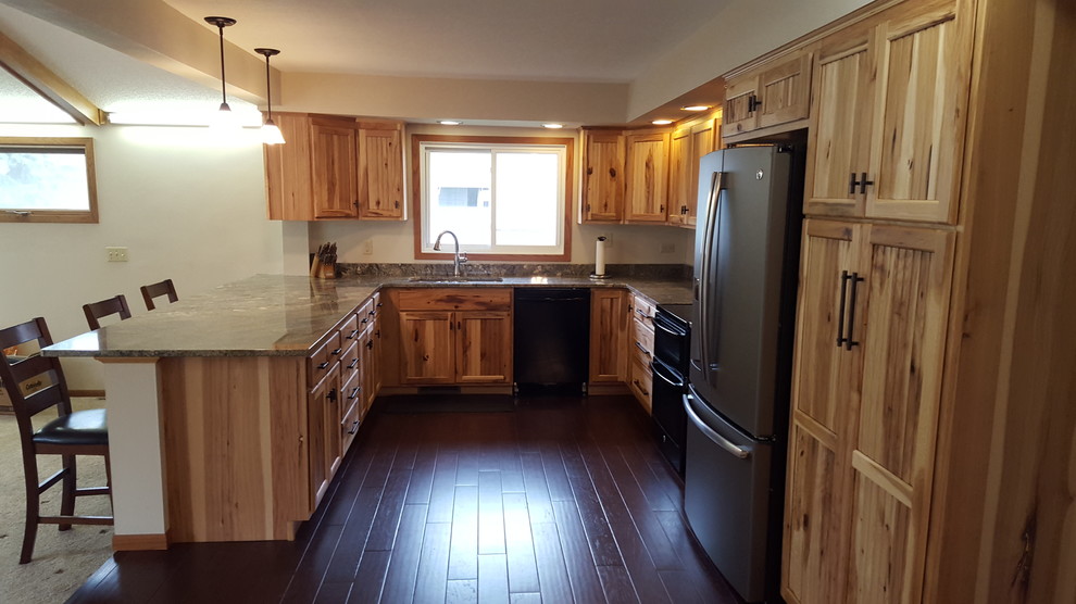 Example of an u-shaped dark wood floor eat-in kitchen design with an undermount sink, stainless steel appliances and a peninsula