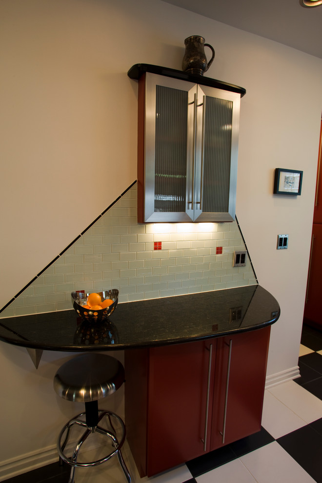 Inspiration for a small modern l-shaped eat-in kitchen in Indianapolis with an undermount sink, flat-panel cabinets, black cabinets, granite benchtops, multi-coloured splashback, glass tile splashback, stainless steel appliances, ceramic floors and a peninsula.