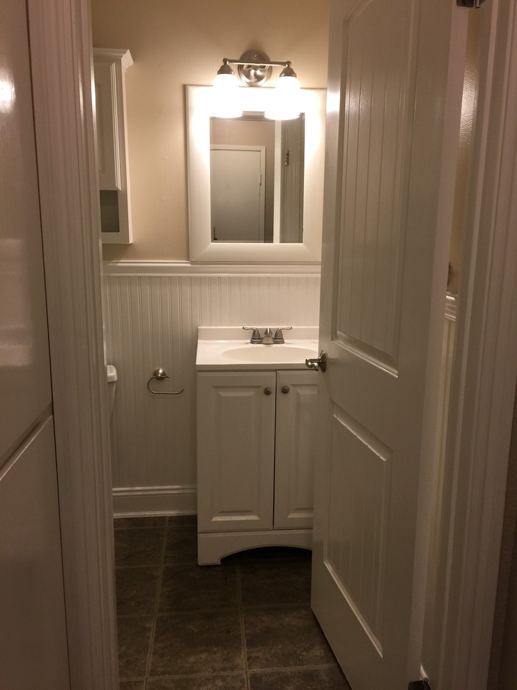 Inspiration for a small traditional 3/4 bathroom in San Francisco with raised-panel cabinets, white cabinets, a two-piece toilet, beige walls, ceramic floors, an integrated sink, engineered quartz benchtops, brown floor, an alcove shower and a sliding shower screen.