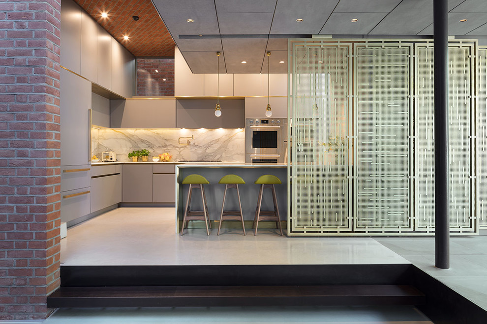 Inspiration for a large contemporary l-shaped open plan kitchen in London with a submerged sink, flat-panel cabinets, grey cabinets, marble worktops, white splashback, marble splashback, stainless steel appliances, concrete flooring, an island, grey floors and white worktops.