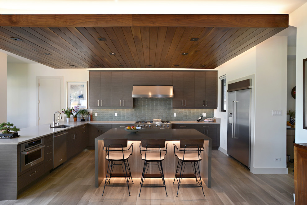 Design ideas for a mid-sized modern u-shaped eat-in kitchen in Dallas with an undermount sink, flat-panel cabinets, brown cabinets, quartz benchtops, green splashback, ceramic splashback, stainless steel appliances, medium hardwood floors, with island, brown floor and grey benchtop.