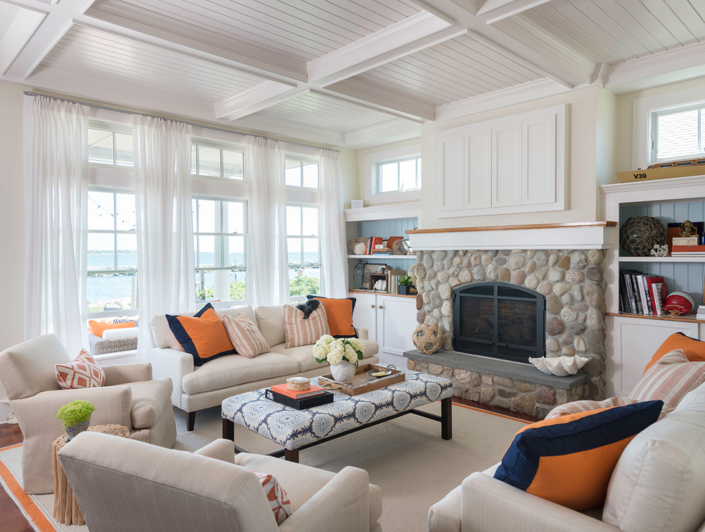 Design ideas for a mid-sized beach style open concept living room in Providence with white walls, a standard fireplace, a stone fireplace surround and a concealed tv.