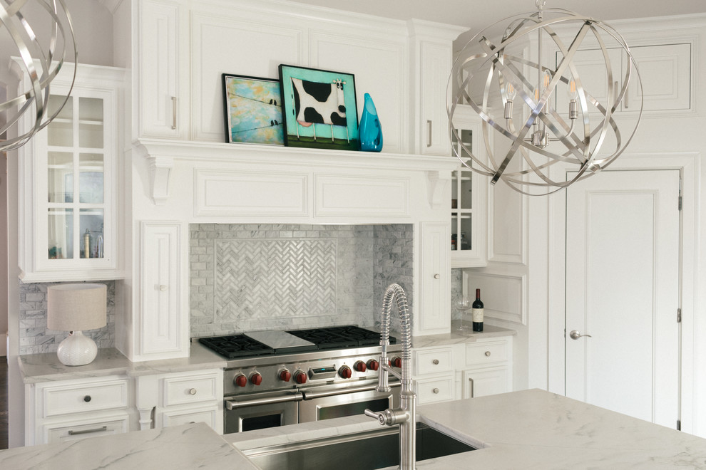 Inspiration for a large transitional u-shaped medium tone wood floor and brown floor eat-in kitchen remodel in Atlanta with an undermount sink, raised-panel cabinets, white cabinets, marble countertops, white backsplash, marble backsplash, stainless steel appliances and an island