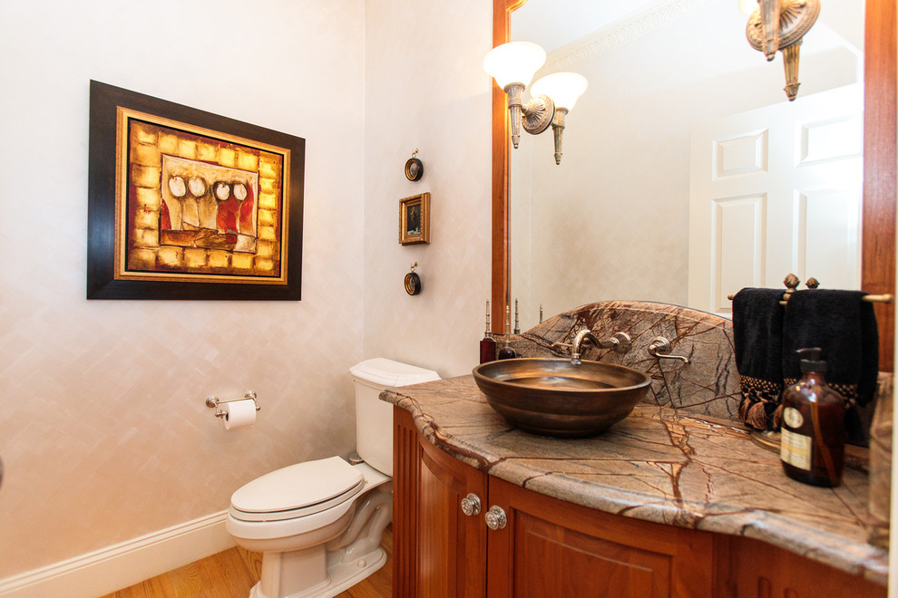 This is an example of a mid-sized traditional 3/4 bathroom in Boston with raised-panel cabinets, medium wood cabinets, a two-piece toilet, beige walls, a vessel sink and marble benchtops.