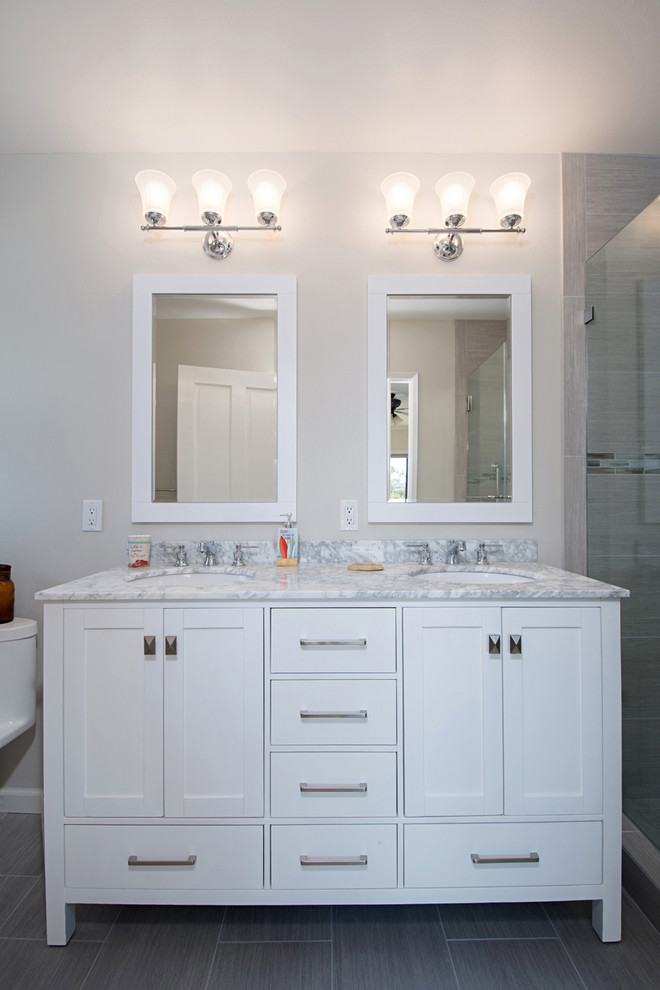 This is an example of a small beach style master bathroom in San Diego with recessed-panel cabinets, white cabinets, an alcove tub, a double shower, a two-piece toilet, gray tile, porcelain tile, grey walls, porcelain floors, an undermount sink, quartzite benchtops, grey floor and a sliding shower screen.