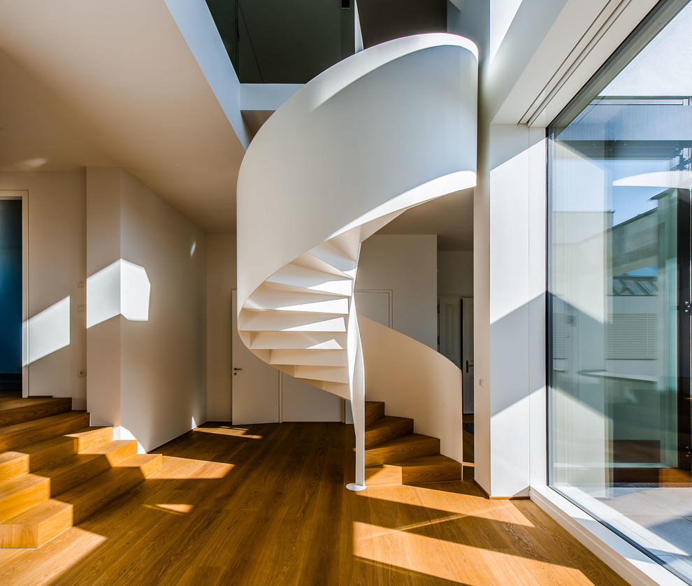 This is an example of a modern wood spiral staircase in Other with wood risers.