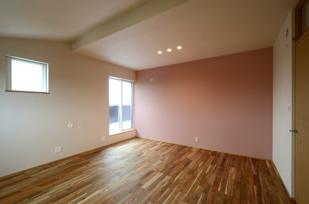 Idéer för att renovera ett mellanstort funkis könsneutralt barnrum kombinerat med sovrum och för 4-10-åringar, med rosa väggar och mellanmörkt trägolv