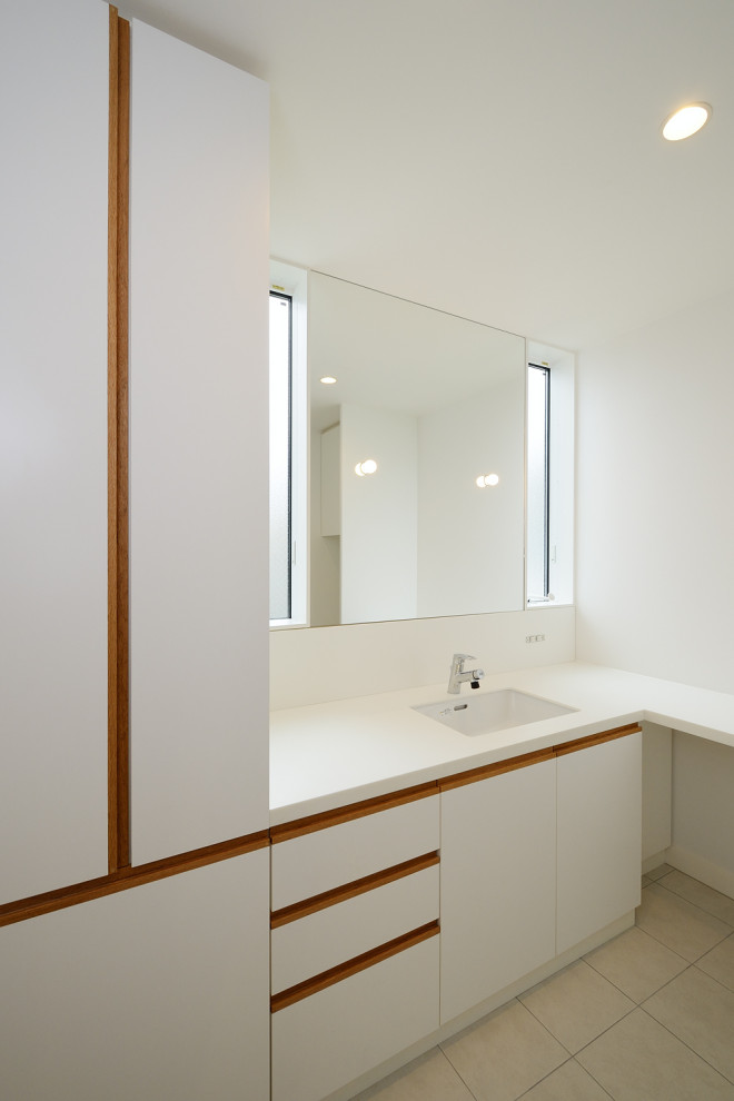 他の地域にある高級な中くらいな北欧スタイルのおしゃれなトイレ・洗面所 (フラットパネル扉のキャビネット、白いキャビネット、白い壁、セラミックタイルの床、一体型シンク、木製洗面台、ベージュの床、白い洗面カウンター、造り付け洗面台、クロスの天井、壁紙、白い天井) の写真