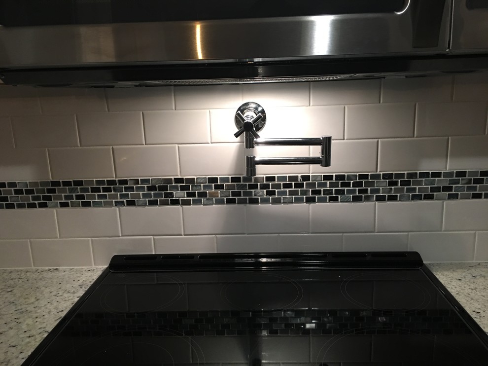 Example of a large transitional galley ceramic tile eat-in kitchen design with an undermount sink, raised-panel cabinets, dark wood cabinets, granite countertops, stainless steel appliances, no island, white backsplash and subway tile backsplash