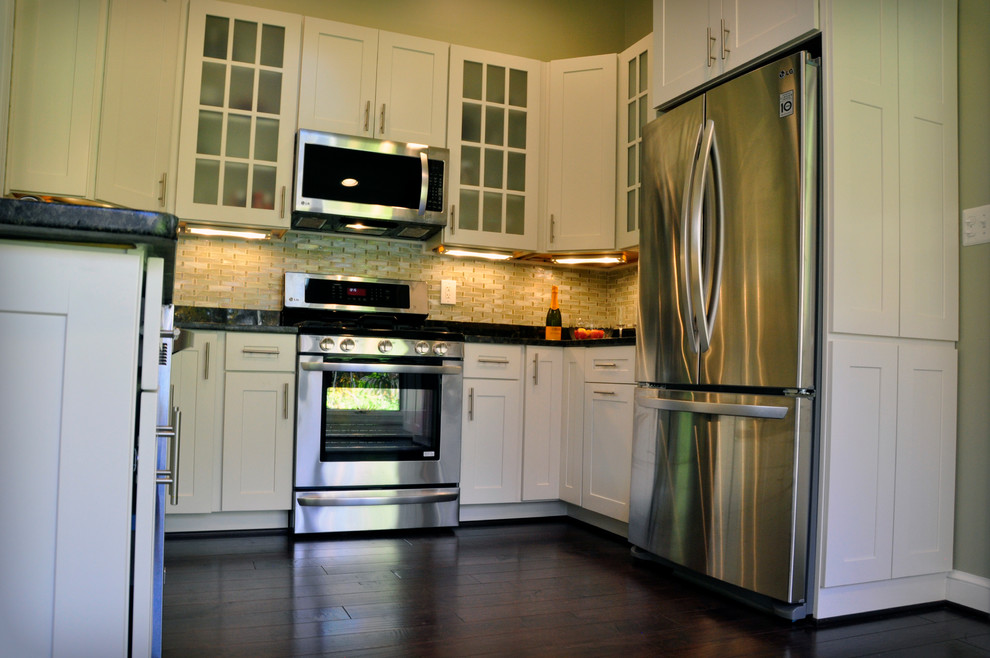 Eat-in kitchen - mid-sized transitional u-shaped dark wood floor eat-in kitchen idea in DC Metro with an undermount sink, shaker cabinets, white cabinets, granite countertops, yellow backsplash, glass tile backsplash, stainless steel appliances and a peninsula