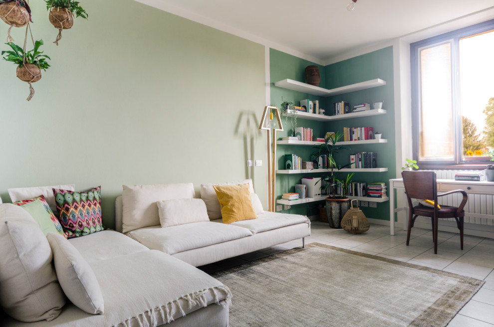 Immagine di un soggiorno design di medie dimensioni e chiuso con libreria, pareti verdi, pavimento in gres porcellanato, pavimento beige e tappeto