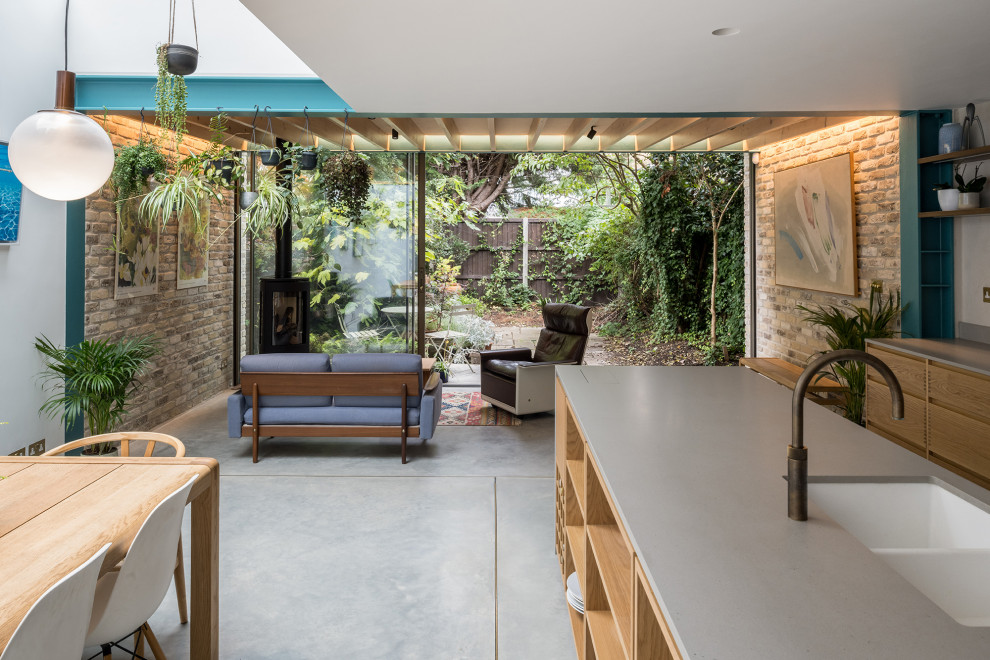Immagine di una cucina abitabile minimal di medie dimensioni con pavimento in cemento