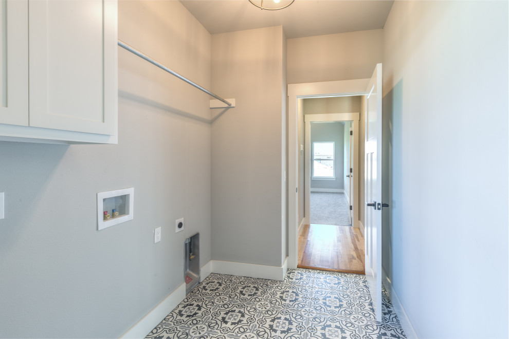Photo of a transitional dedicated laundry room in Other with shaker cabinets, white cabinets, grey walls, ceramic floors and multi-coloured floor.