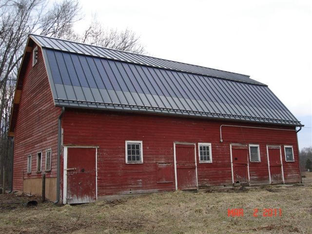 Mid-sized traditional one-storey red exterior in Other with wood siding.