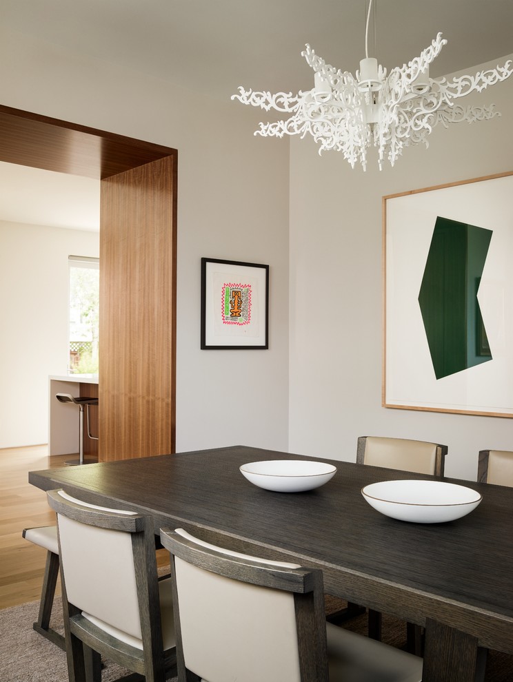 This is an example of a contemporary separate dining room in San Francisco with beige walls and medium hardwood floors.