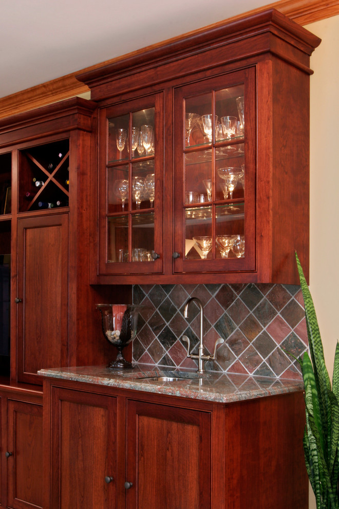 Photo of a traditional single-wall wet bar in Boston with an undermount sink, shaker cabinets, dark wood cabinets and carpet.