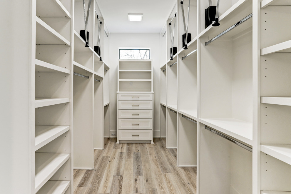 Inspiration for a large transitional gender-neutral walk-in wardrobe in Houston with recessed-panel cabinets, white cabinets, light hardwood floors and multi-coloured floor.