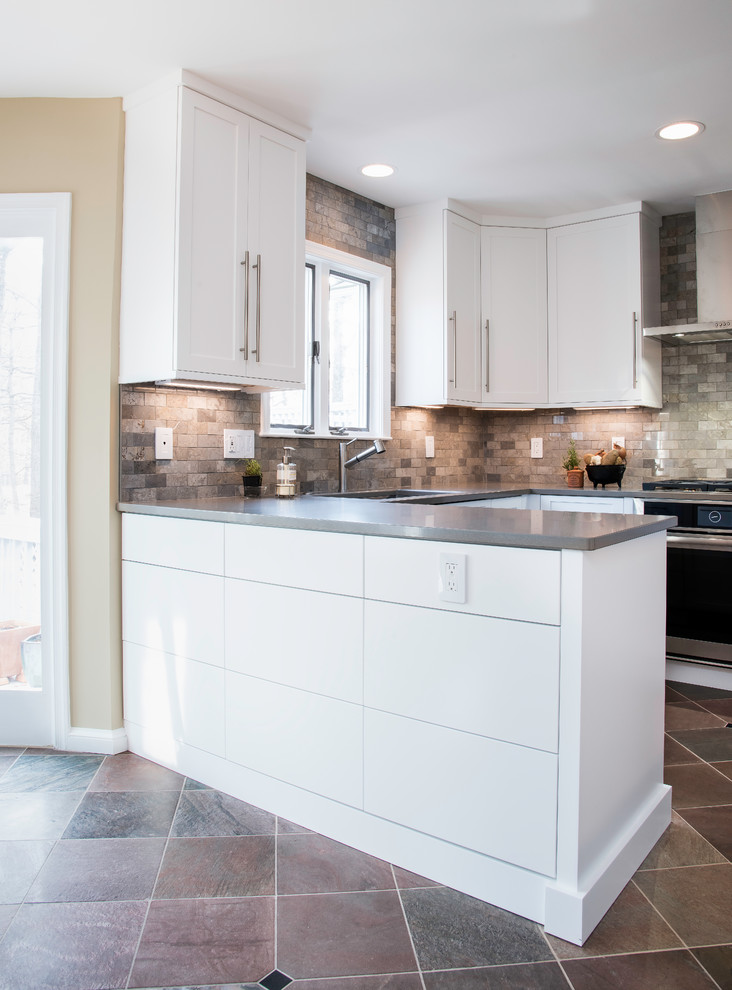 Photo of a mid-sized modern u-shaped separate kitchen in DC Metro with an undermount sink, shaker cabinets, white cabinets, quartz benchtops, multi-coloured splashback, marble splashback, stainless steel appliances, slate floors, a peninsula and multi-coloured floor.