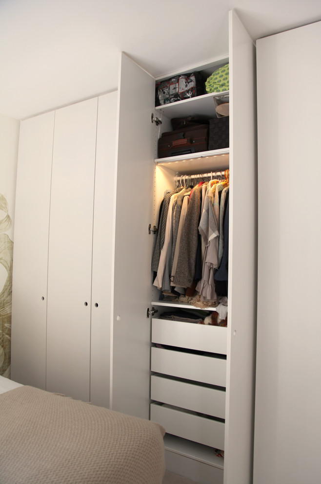 Design ideas for a large contemporary women's built-in wardrobe in Other with beaded inset cabinets, white cabinets, carpet and beige floor.