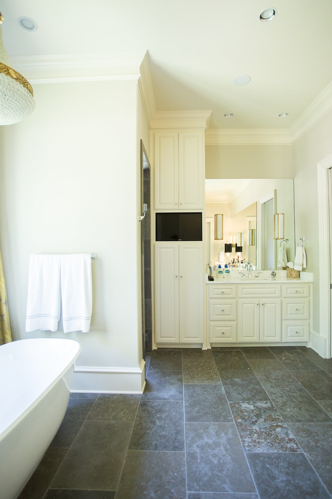 This is an example of a small transitional master bathroom in Austin with raised-panel cabinets, white cabinets, a claw-foot tub, a corner shower, gray tile, stone tile, white walls and slate floors.