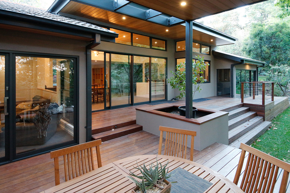 Design ideas for a large contemporary backyard deck in Melbourne with a container garden and a roof extension.