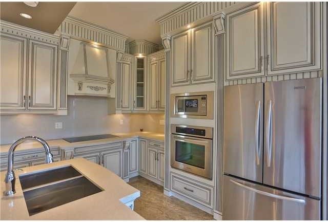 This is an example of a large asian u-shaped eat-in kitchen in Vancouver with an undermount sink, beige cabinets, quartzite benchtops, white splashback, glass sheet splashback, stainless steel appliances, marble floors and with island.