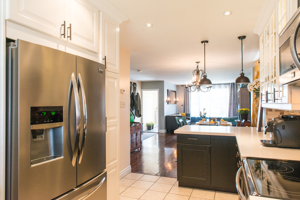Mid-sized transitional u-shaped ceramic tile eat-in kitchen photo in Toronto with an undermount sink, shaker cabinets, black cabinets, quartz countertops, brown backsplash, stone tile backsplash, stainless steel appliances and a peninsula