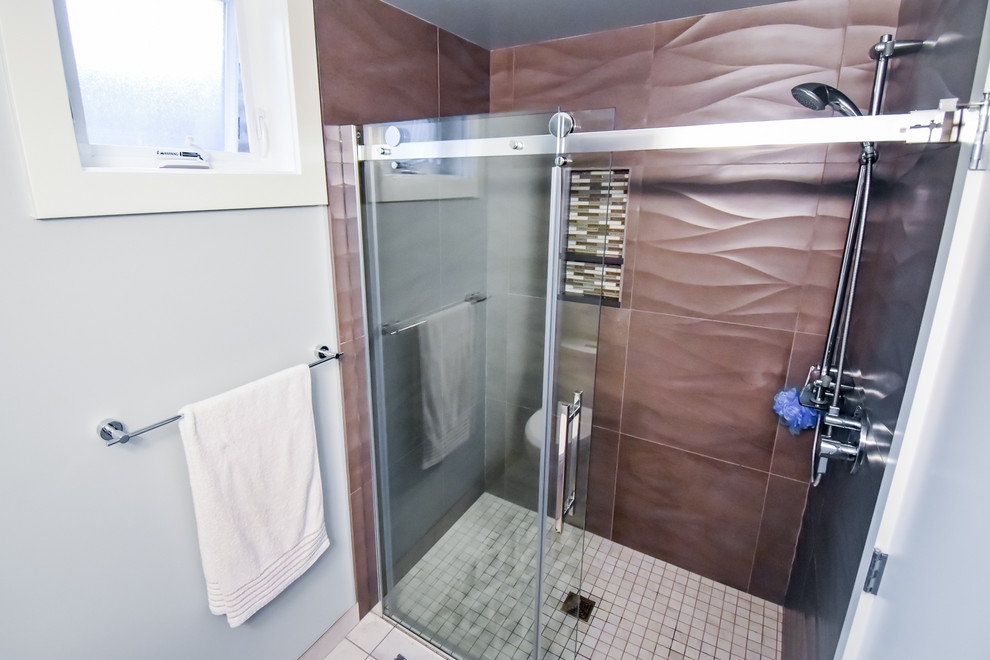 Small modern kids bathroom in Seattle with flat-panel cabinets, dark wood cabinets, an alcove shower, a two-piece toilet, brown tile, blue walls, a pedestal sink, beige floor and a sliding shower screen.