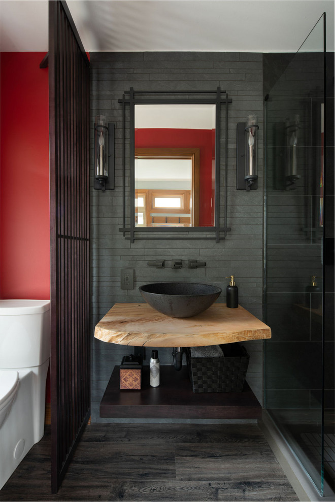 Inspiration for a small transitional 3/4 bathroom in Columbus with an alcove shower, a one-piece toilet, black tile, porcelain tile, red walls, vinyl floors, a vessel sink, wood benchtops, grey floor, a hinged shower door and brown benchtops.