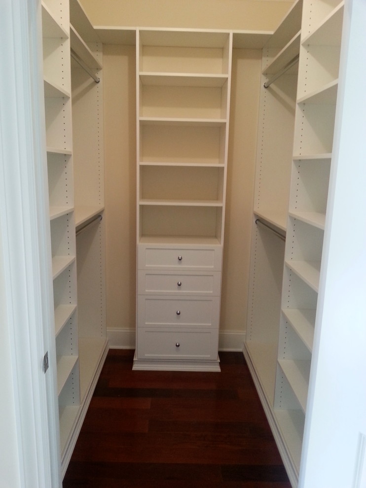 Photo of a mid-sized contemporary women's walk-in wardrobe in New York with open cabinets, white cabinets, dark hardwood floors and brown floor.