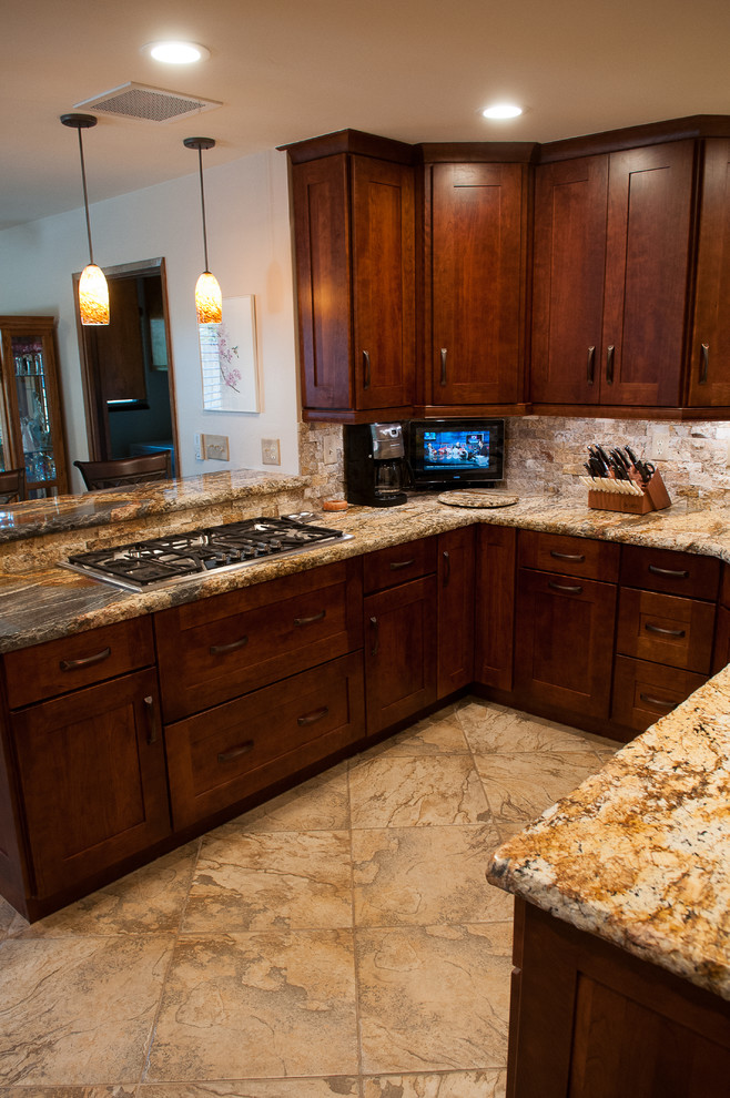 Example of a mid-sized mountain style u-shaped slate floor eat-in kitchen design in Burlington with an undermount sink, shaker cabinets, dark wood cabinets, granite countertops, beige backsplash, stone tile backsplash, stainless steel appliances and a peninsula