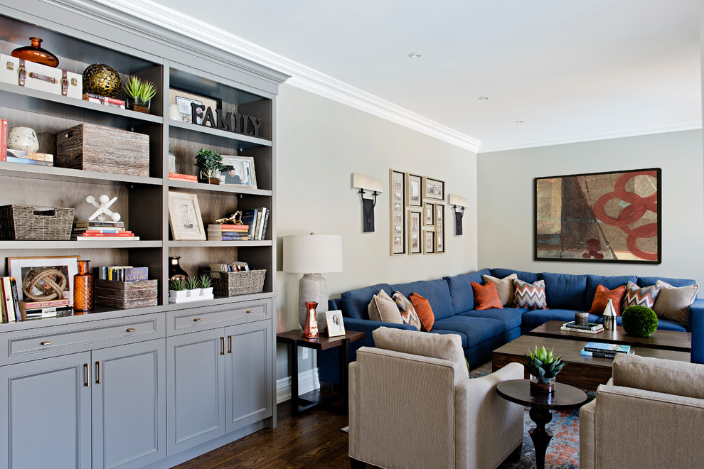 Mid-sized transitional family room in Toronto with grey walls, medium hardwood floors, a standard fireplace, a wood fireplace surround, a wall-mounted tv and brown floor.