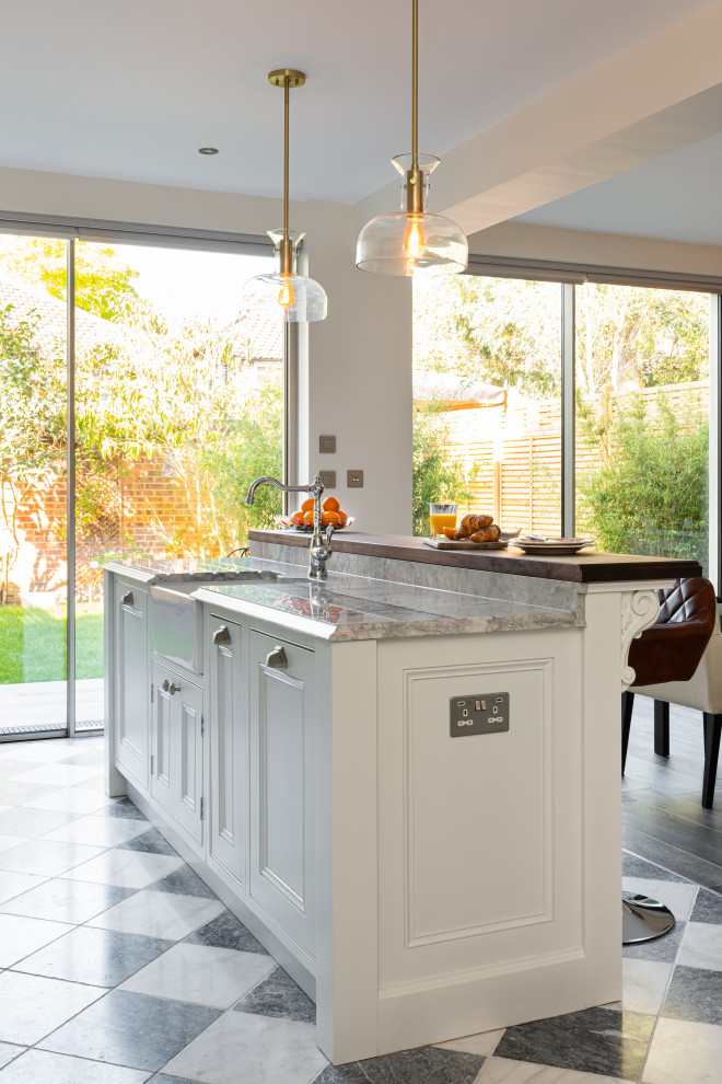 Inspiration for a mid-sized traditional single-wall eat-in kitchen in London with shaker cabinets, white cabinets, quartzite benchtops, grey splashback, granite splashback, stainless steel appliances, with island and grey benchtop.