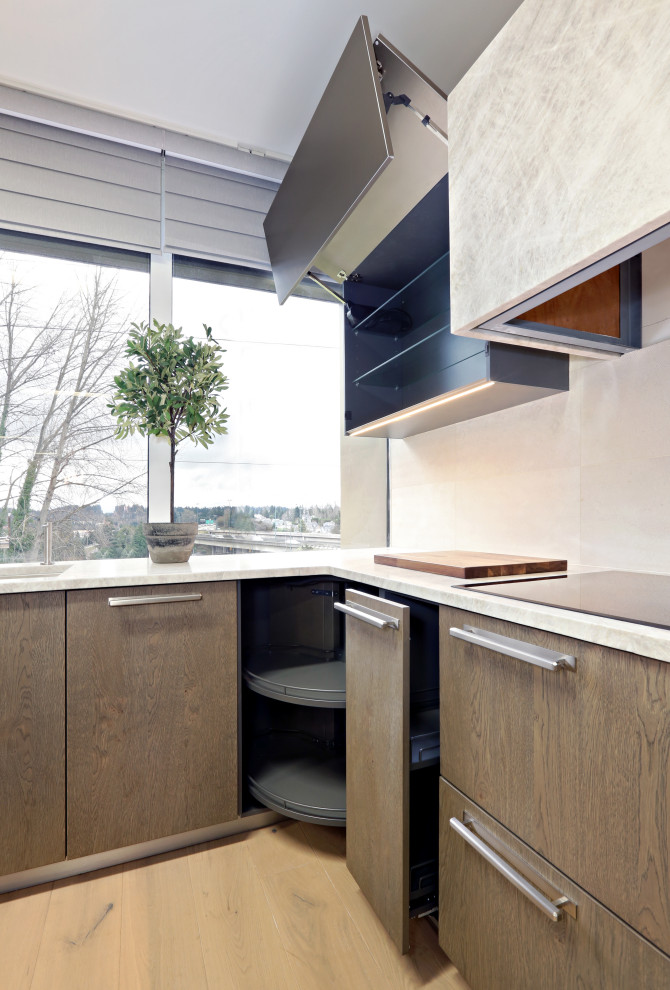 Mid-sized transitional l-shaped light wood floor and beige floor open concept kitchen photo in Seattle with an undermount sink, flat-panel cabinets, gray cabinets, quartzite countertops, beige backsplash, limestone backsplash, stainless steel appliances, an island and beige countertops