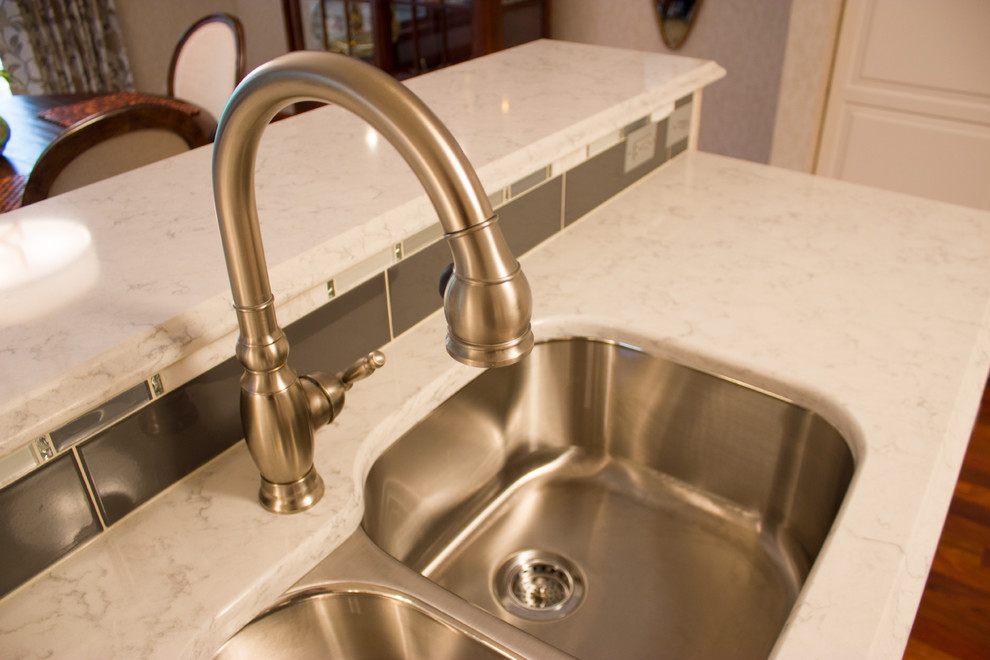 Example of a large transitional u-shaped medium tone wood floor eat-in kitchen design in Cedar Rapids with a double-bowl sink and quartz countertops