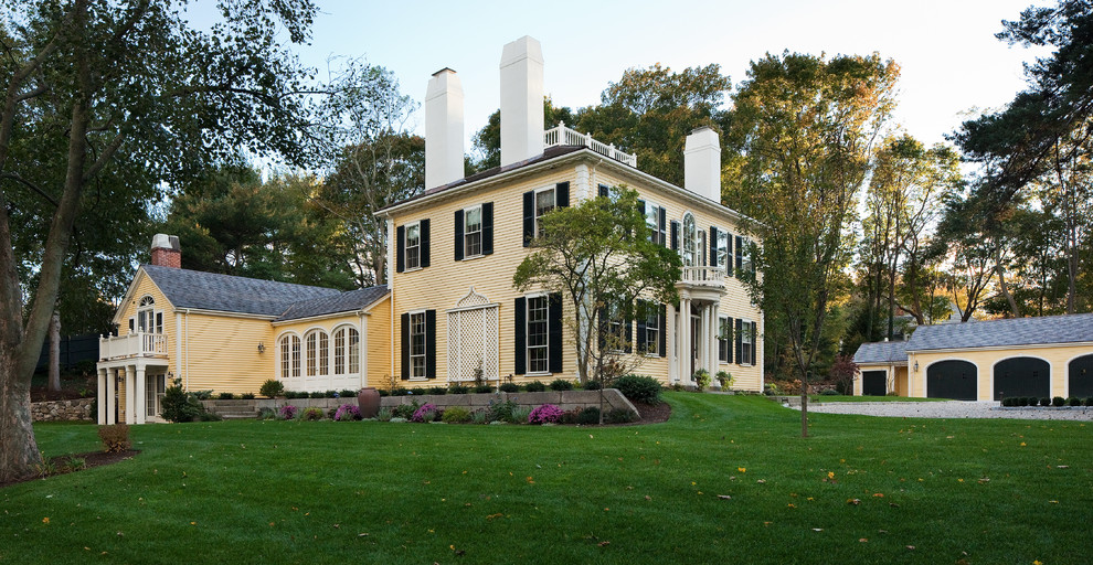 Design ideas for a large traditional two-storey yellow exterior in Boston with wood siding.