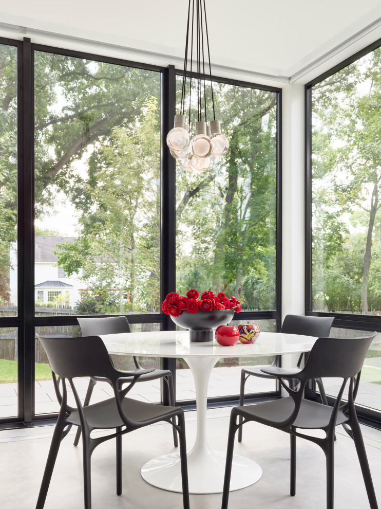 North Shore Less is More - Contemporary kitchen design, surrounded by full height window walls.  This minimal black & white kitchen features three islands with Chanel white and Double black quartzite countertops andconcrete floors.  Walnut wall houses built-in refrigeration a and storage areas.  These touch-to-open full height walnut panels also conceal the pantry area and access to powder room and lower level.