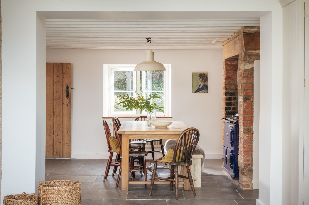 Imagen de comedor de estilo de casa de campo de tamaño medio abierto con paredes blancas, suelo de pizarra y suelo gris