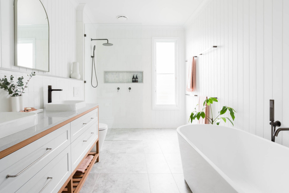 Inspiration for a contemporary family bathroom in Brisbane with shaker cabinets, a freestanding bath, white tiles, white walls, engineered stone worktops, grey floors, grey worktops and double sinks.
